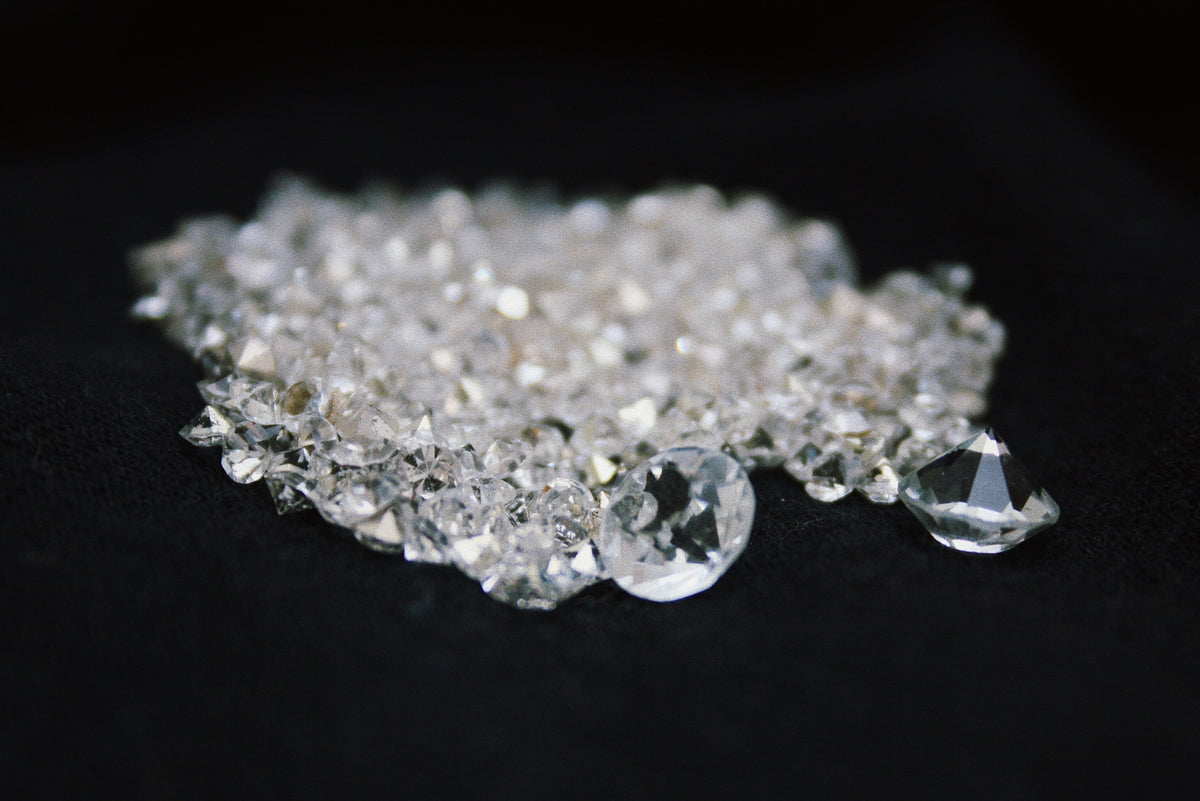 Clear faceted gemstones scattered on a black surface